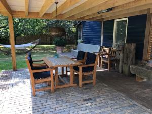 a wooden table and chairs on a patio at Eersel's Groen in Eersel