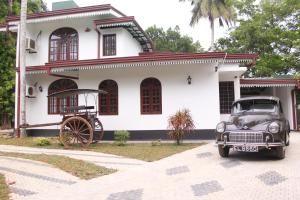 an old car parked in front of a house at Sethra Villa Bentota in Bentota