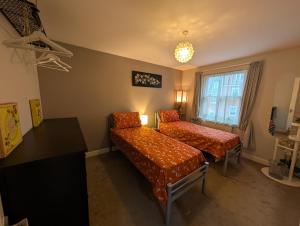a room with two beds and a couch and a window at Namastay-Central Glastonbury in Glastonbury