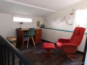Zimmer mit einem Schreibtisch, einem roten Stuhl und einem Schreibtisch. in der Unterkunft charmante maisonnette au calme in Montélimar