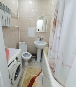 a bathroom with a sink and a toilet and a shower at Однокомнатная на Хиуаз Доспановой 73 in Uralsk