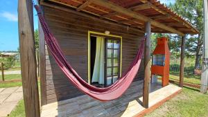 a hammock on the back of a house at Chalé Tribos Livres in Torres
