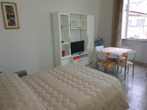 a bedroom with a bed and a table and a television at Risorgimento House in Catania