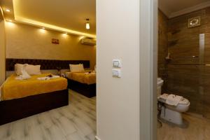 una camera d'albergo con due letti e un bagno di PYRAMIDS guest house a Il Cairo