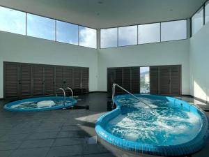 two jacuzzi tubs in a large room with windows at Ammara Homestay 2 Palas Horizon Kea Farm in Cameron Highlands