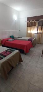 une chambre avec deux lits avec des couvertures rouges dans l'établissement Casa Tierra del Fuego, à Santa Rosa