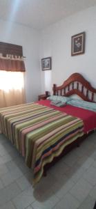 - une chambre avec un lit et une couverture colorée dans l'établissement Casa Tierra del Fuego, à Santa Rosa