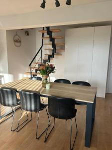 a dining room with a table and chairs and a staircase at Duplex appartement, Burcht in Zwijndrecht