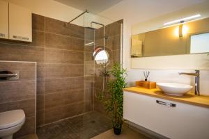 a bathroom with a toilet and a sink and a shower at Kisara, Villa moderne 6 pers Piscine in Saint-François +20 photos