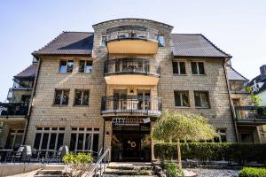 a large brick building with balconies on it at Hotel CityHome am Kurpark in Bad Salzuflen