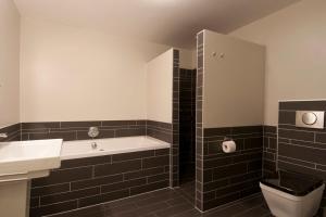 a bathroom with a tub and a sink and a toilet at B&B Zondag in Eys