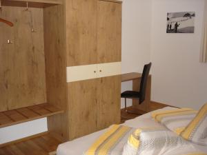 a bedroom with a bed and a desk and a cabinet at Haus Wallner in Klösterle am Arlberg