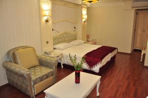Habitación de hotel con cama y silla en Muyan Suites en Estambul