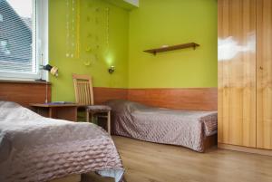 1 dormitorio con 2 camas y paredes verdes en Guest House Wanda, en Wałbrzych