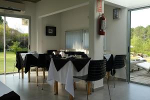 a dining room with black and white tables and chairs at Dalarna Små Hotell in Punta del Este
