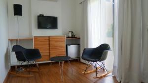 a living room with three chairs and a television at Dalarna Små Hotell in Punta del Este