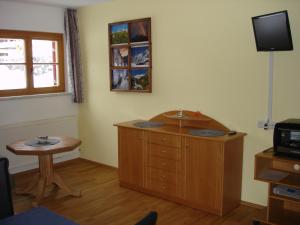 een kamer met een bureau, een tafel en een televisie bij Haus Wallner in Klösterle am Arlberg