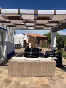 a patio with a couch and chairs under a pergola at Casa do Monte T2 - Esperança in Arronches