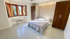 a bedroom with a bed and a table in it at Casa praia bombinhas 130m mar in Bombinhas