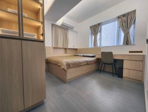 a bedroom with a bed and a desk and a window at Pillows CoLiving in Hong Kong