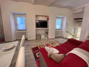 Una sala de estar con un sofá rojo y un televisor. en Tolletta 10eLode, en Arezzo