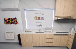a kitchen with a sink and fruit on the wall at Pillows CoLiving in Hong Kong