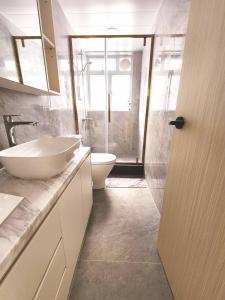 a white bathroom with a sink and a toilet at Pillows CoLiving in Hong Kong