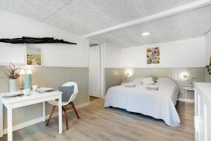 a bedroom with a bed and a desk and a table at Danzigmand Bed and Breakfast in Læsø +1 photo