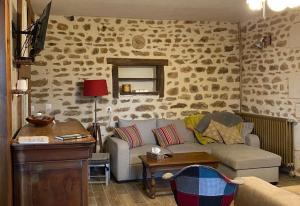 a living room with a couch and a table at Gîte La Cahute in Bourganeuf