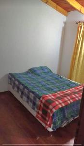 - un lit avec une couverture tressée dans une chambre dans l'établissement Casa en Puerto Santa Cruz, à Puerto Santa Cruz
