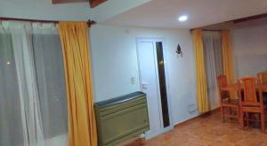 - un salon avec une télévision et quelques rideaux dans l'établissement Casa en Puerto Santa Cruz, à Puerto Santa Cruz 1 autre photo