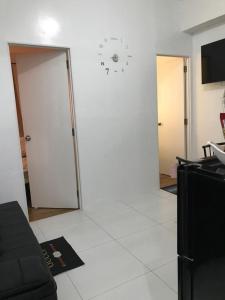 a white living room with a clock on the wall at Condotel 2 bedroom with terrace and free car parking in Naga