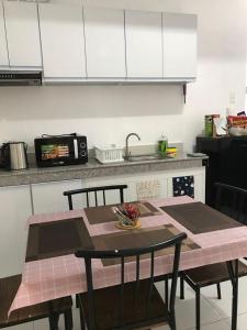 a kitchen with a table with chairs and a sink at Condotel 2 bedroom with terrace and free car parking in Naga +12 photos