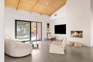 a living room with white furniture and a fireplace at Zendo House By The Cohost Company in Joshua Tree