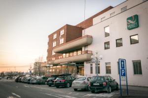 una fila de autos estacionados frente a un edificio en Quality Hotel Grand Steinkjer, en Steinkjer