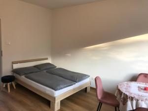a bedroom with a bed and a table and chairs at Obermais garden living in Merano