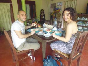 a man and woman sitting at a table eating food at The Nilmini Lodge in Sigiriya +39 photos