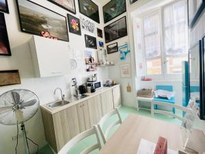 a kitchen with a sink and a table with a fan at Hackert Art Room Apartment in Caserta