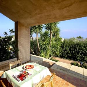 a table with a plate of fruit on a patio at Residence Costamartino in Vieste