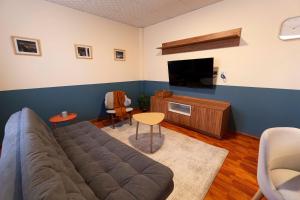 a living room with a couch and a flat screen tv at Habita Sucre in Sucre