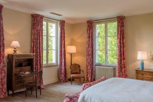 a bedroom with a bed and two windows at Château Le Pape B&B in Léognan