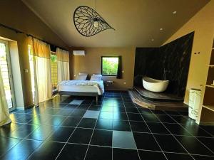 una camera con letto e vasca da bagno di Villa - Domaine à GRANS grande demeure 6 à 12pers a Grans