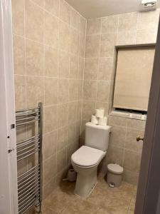 Un pequeño baño con inodoro y ventana. en Bungalow house, en Bradford