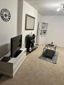 Una sala de estar con un televisor de pantalla plana sobre una cómoda. en Bungalow house, en Bradford