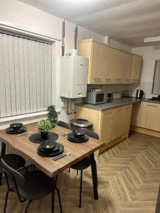 una cocina con mesa de madera y sillas. en Bungalow house, en Bradford 16 fotos más