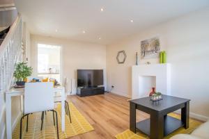 a living room with a table and a television at Lena House in Glasgow +22 photos