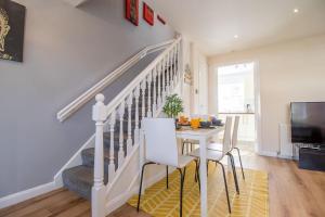 a dining room with a staircase and a table and chairs at Lena House in Glasgow