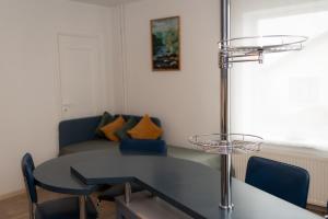 a dining room table with blue chairs and a couch at Apartment Maria in Cēsis