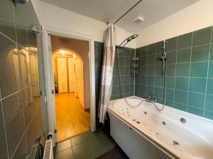 a bathroom with a bath tub and a shower at Apartment Maria in Cēsis +8 photos