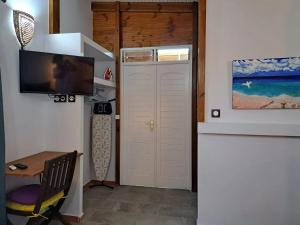 una camera con una porta con televisore e tavolo di Bungalow cosy avec jardin au Gosier, 40 m² a Le Gosier Altre 14 foto